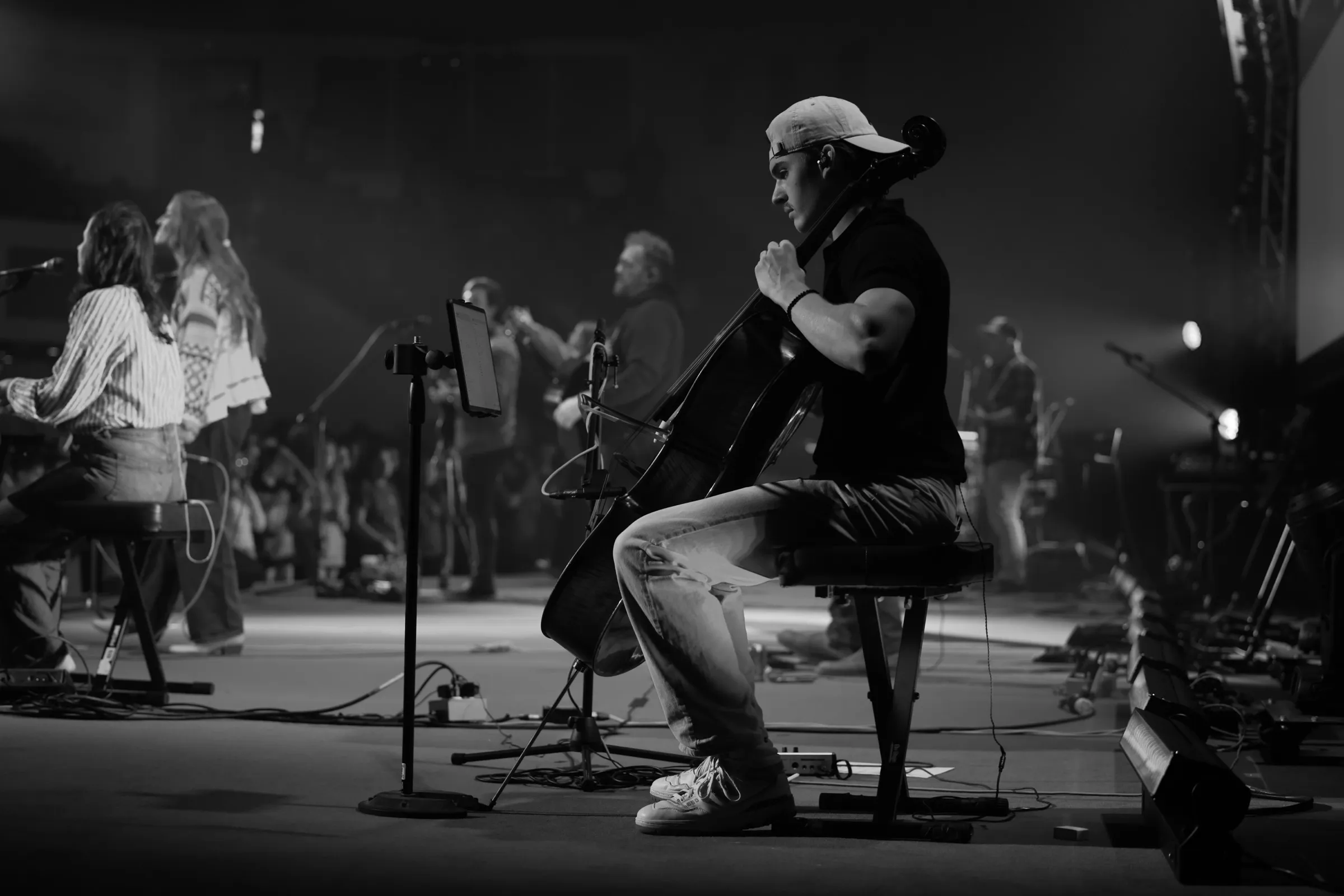 A cellist playing during a worship night, black and white