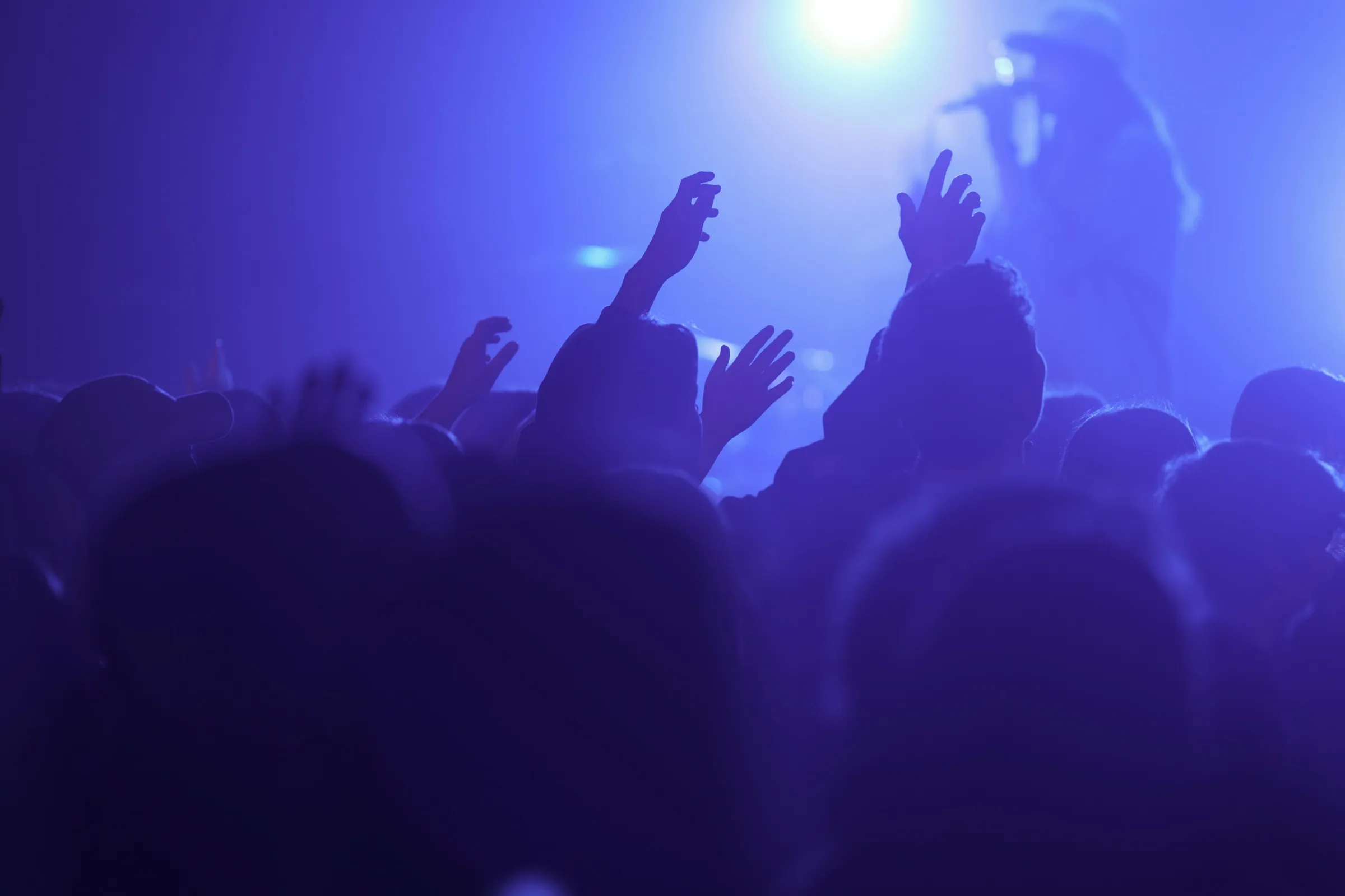 Silhouetted crowd with raised hands at a Red Letter Society worship night