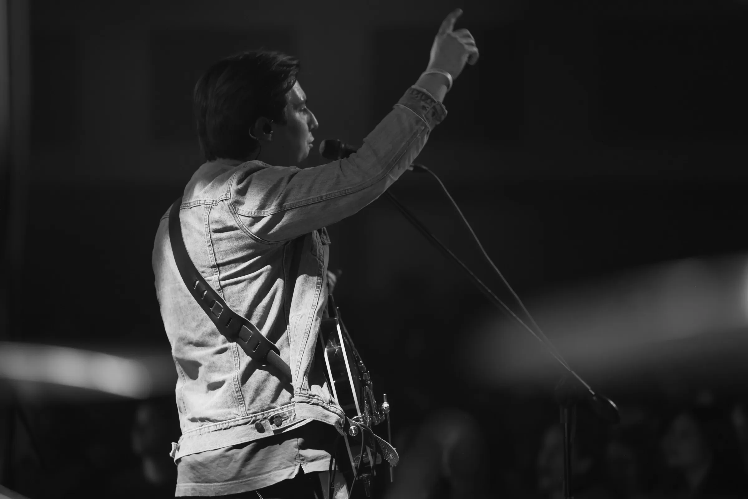 A Red Letter Society worship leader at the mic, in black and white